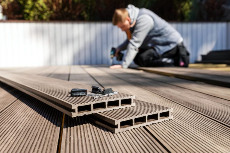 This image shows an expert deck contractor installing a composite board deck.