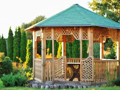A picture of a beautiful gazebo with bench in a scenic sunny area.